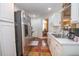 Modern kitchen featuring stainless steel appliances, bright countertops, and hardwood flooring flowing into the dining space at 241 Lost Lake Way, Villa Rica, GA 30180