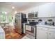 Bright kitchen featuring stainless steel appliances, white cabinets, and hardwood floors extending to the breakfast nook at 241 Lost Lake Way, Villa Rica, GA 30180