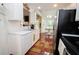 Functional kitchen featuring stainless steel appliances, light countertops, and hardwood floors leading to the dining area at 241 Lost Lake Way, Villa Rica, GA 30180