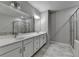 Bright bathroom featuring double vanity with white cabinets, large mirror, and tiled shower at 315 Duval Dr, Alpharetta, GA 30009