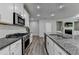 Bright, modern kitchen with granite counters, stainless appliances, and open layout to living area at 315 Duval Dr, Alpharetta, GA 30009