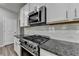 Close-up of kitchen featuring stainless steel range, granite counters, and subway tile backsplash at 315 Duval Dr, Alpharetta, GA 30009