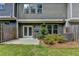 Back of house with small patio and yard with fence, bushes, and exterior utilities at 315 Duval Dr, Alpharetta, GA 30009