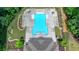 High-angle view of a bright blue community pool with a large deck area with seating, surrounded by lawn and trees at 315 Duval Dr, Alpharetta, GA 30009