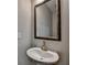 Elegant powder room with a pedestal sink, framed mirror, and neutral wall color, offering a stylish space at 315 Duval Dr, Alpharetta, GA 30009