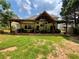 Expansive backyard with a covered patio, featuring outdoor kitchen, dining, and seating areas for entertaining at 134 Carolinas Way, Fayetteville, GA 30215