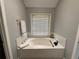 Clean bathroom showcasing a deep soaking tub and bright neutral walls at 134 Carolinas Way, Fayetteville, GA 30215