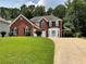 Charming two-story red brick home with a well-manicured lawn and a two-car garage at 134 Carolinas Way, Fayetteville, GA 30215