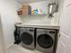 Organized laundry room featuring washer, dryer, built in shelving, and modern appliances at 134 Carolinas Way, Fayetteville, GA 30215
