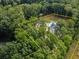 Expansive aerial view of a secluded estate with mature trees, a pool, and a defined property line at 3640 Pollys Blf, Cumming, GA 30028