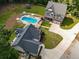 Aerial view showcasing the kidney bean-shaped pool, backyard trampoline, and mature trees at 3640 Pollys Blf, Cumming, GA 30028