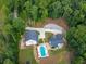 Aerial view showcases a driveway and 2 homes with a kidney bean-shaped pool and expansive lawn at 3640 Pollys Blf, Cumming, GA 30028