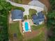 Aerial view featuring a kidney-shaped pool, expansive lawn, and a concrete driveway at 3640 Pollys Blf, Cumming, GA 30028
