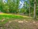 Grassy backyard featuring a rustic wooden fence and a storage shed in the distance at 3640 Pollys Blf, Cumming, GA 30028