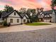Gorgeous home exterior with lush landscaping, stone accents, and a long driveway leading to ample parking at 3640 Pollys Blf, Cumming, GA 30028