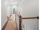 Upstairs hallway featuring wood floors, wood banisters, white trim and plenty of light at 3640 Pollys Blf, Cumming, GA 30028