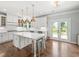 Spacious kitchen with white cabinets, stainless steel appliances and a center island with seating at 3640 Pollys Blf, Cumming, GA 30028