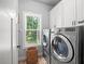 Spacious laundry room featuring front-load washer and dryer with a window and brick floor at 3640 Pollys Blf, Cumming, GA 30028