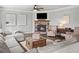 Inviting living room featuring a stone fireplace, ceiling fan, and comfortable neutral-toned furniture at 3640 Pollys Blf, Cumming, GA 30028