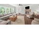 Bright living room featuring a stone fireplace, ceiling fan, and hardwood flooring at 3640 Pollys Blf, Cumming, GA 30028