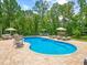 Backyard with an inviting in-ground pool surrounded by lounge furniture and lush landscaping at 3640 Pollys Blf, Cumming, GA 30028