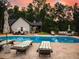 Inviting pool area featuring ample seating, lush greenery, and a clear view of the home at sunset at 3640 Pollys Blf, Cumming, GA 30028