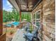 Inviting covered porch features comfortable seating, stone accents, and a view of the pool, perfect for outdoor relaxation at 3640 Pollys Blf, Cumming, GA 30028