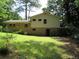 Exterior shot of a two-story home's rear facade, showing a brick foundation, vinyl siding, and a grassy lawn at 5114 Fawn Se Trl, Mableton, GA 30126