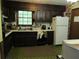 Traditional kitchen with dark wood cabinets, vintage appliances, and green checkered flooring at 5114 Fawn Se Trl, Mableton, GA 30126