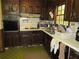 Traditional kitchen with dark wood cabinets, vintage appliances, and checkered flooring at 5114 Fawn Se Trl, Mableton, GA 30126