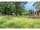 A view of the grassy backyard with mature trees, shed, deck, and covered pool at 96 S Forty Pass S, Hiram, GA 30141