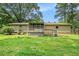 A view of the back of the house, back deck, screened porch, large yard, and mature trees at 96 S Forty Pass S, Hiram, GA 30141