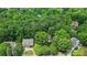 A high aerial view of a neighborhood nestled within a dense forest, showcasing the community's natural setting at 1788 River Bluff Vw, Duluth, GA 30097