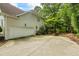 Exterior view of the home showing the driveway, garage, and lush backyard with mature trees at 1788 River Bluff Vw, Duluth, GA 30097