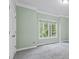 Bright bedroom with two windows, neutral carpeting, and mint green walls at 1788 River Bluff Vw, Duluth, GA 30097