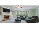 Bright living room with stone fireplace, built-in shelving, and large windows overlooking the backyard at 1788 River Bluff Vw, Duluth, GA 30097