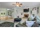 Open-concept living room with built-in shelving, fireplace, plush seating, and views into other living spaces at 1788 River Bluff Vw, Duluth, GA 30097