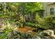 Tranquil backyard koi pond with waterfall, lush greenery, and a view of the home at 1788 River Bluff Vw, Duluth, GA 30097