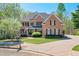 Traditional brick home with well-manicured lawn, mature landscaping, and a paved driveway at 205 Northampton Ct, Canton, GA 30115