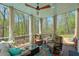 Relaxing screened-in porch with comfortable seating, ceiling fan, and a view of the wooded backyard at 205 Northampton Ct, Canton, GA 30115
