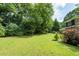 Expansive backyard featuring a lush lawn and mature trees providing shade and privacy at 2340 Castleridge Ct, Tucker, GA 30084