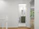 Hallway view into bathroom with modern green vanity, elegant mirror, and sleek fixtures at 2340 Castleridge Ct, Tucker, GA 30084