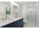 Modern bathroom with double vanity, large mirrors, and walk-in shower featuring glass door at 2340 Castleridge Ct, Tucker, GA 30084