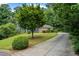 Long driveway leads to a charming home with lush landscaping, blending elegance and nature at 2340 Castleridge Ct, Tucker, GA 30084