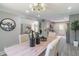 Open concept dining area with stylish chandelier, table setting and view of the living room and kitchen at 243 Hickory Way, Canton, GA 30115