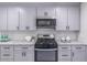 Well-lit kitchen featuring stainless steel appliances, sleek gray cabinets, and modern fixtures at 243 Hickory Way, Canton, GA 30115