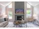 Bright living room features a stone fireplace, large windows and modern decor at 243 Hickory Way, Canton, GA 30115