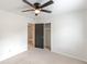 Bedroom featuring neutral carpet, closet, ceiling fan and a view into the laundry area at 3109 Albatross Ln, Decatur, GA 30034