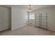 This is a bedroom with a decorative light fixture, shelving, neutral carpet and two windows at 3109 Albatross Ln, Decatur, GA 30034