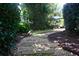 Lush landscaped backyard with a stone pathway and manicured lawn and bushes at 7825 Crownpoint Dr, Alpharetta, GA 30005